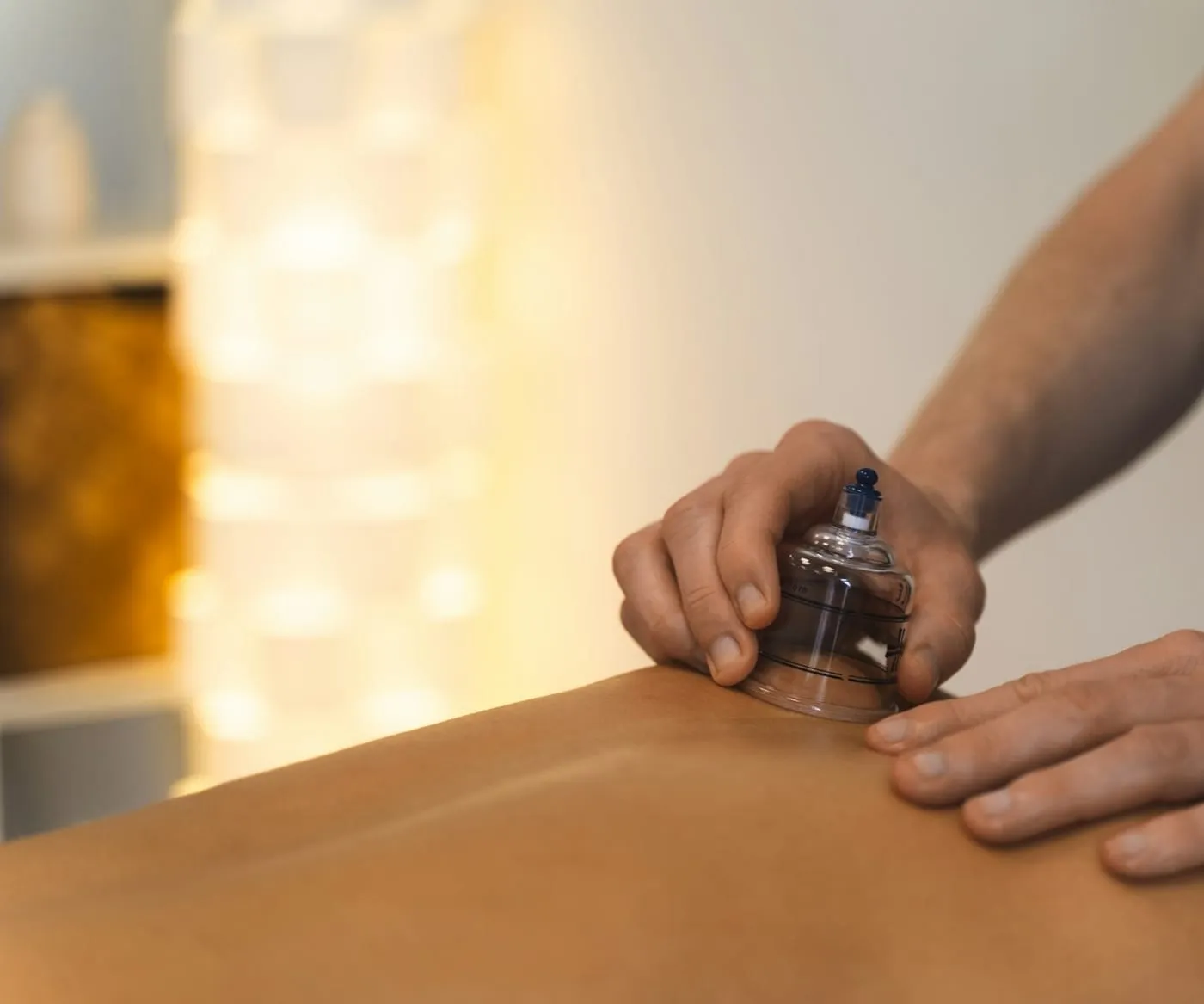 A cup being applied to the muscles of the upper back