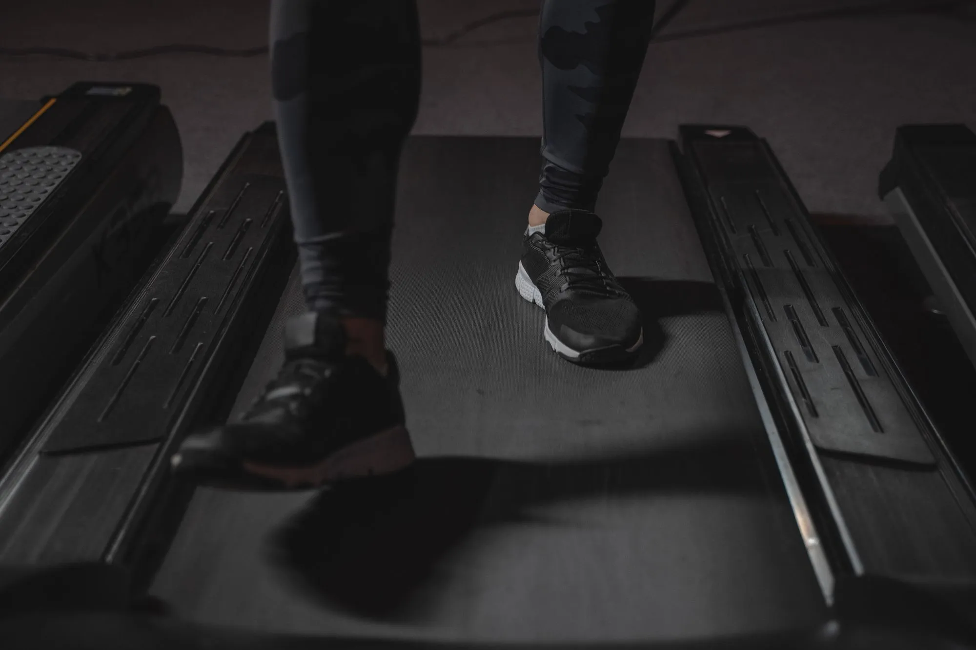 Running shoes mid-stride on a treadmill during a gait assessment
